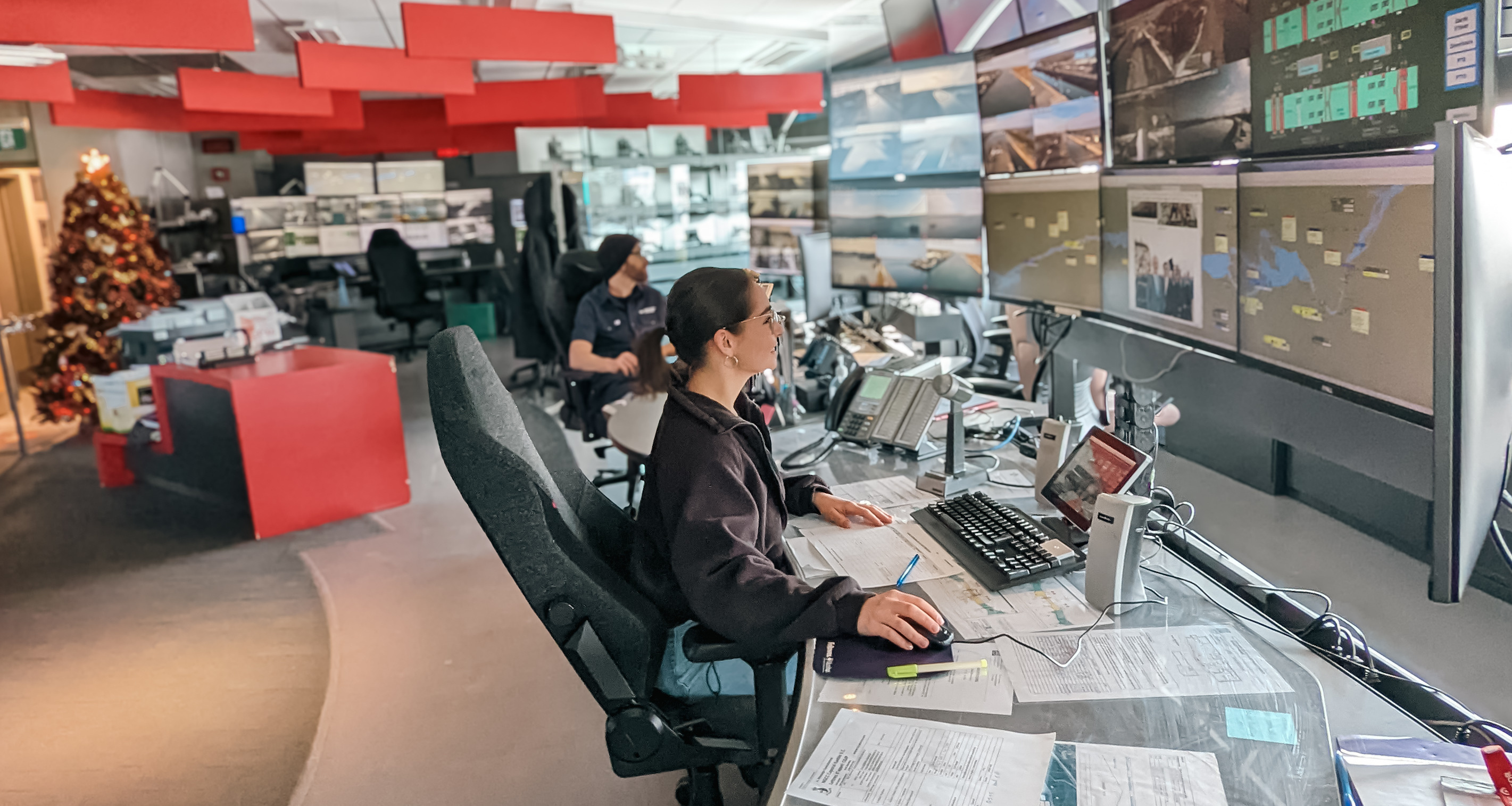 Une femme est assise à un bureau avec plusieurs écrans devant elle au centre d'opérations de l'écluse de Saint-Lambert.