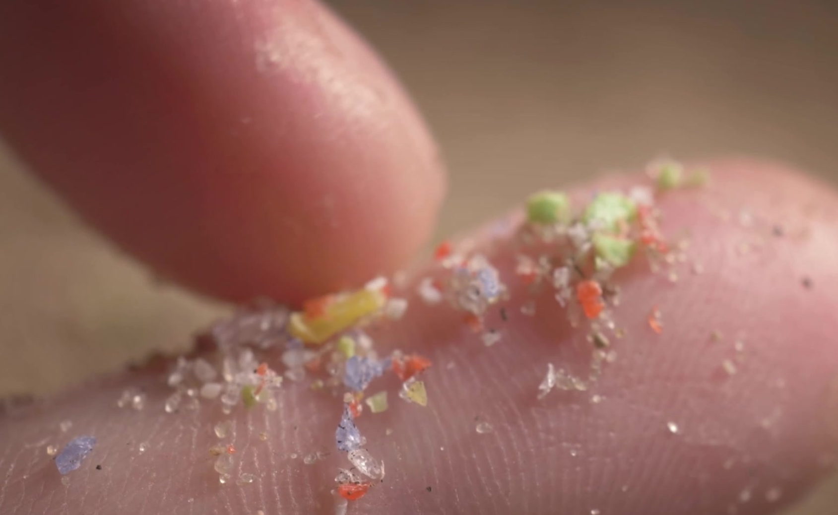 Image of colorful micro plastics on a finger