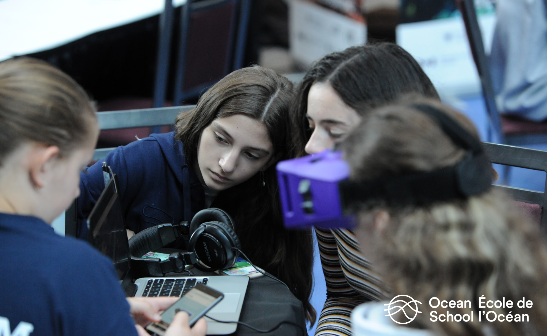 Quatre élèves explorent des activités: deux d’entre eux regardent l’écran d’un ordinateur portable, l’un a un casque de réalité virtuelle et un autre regarde un téléphone intelligent.