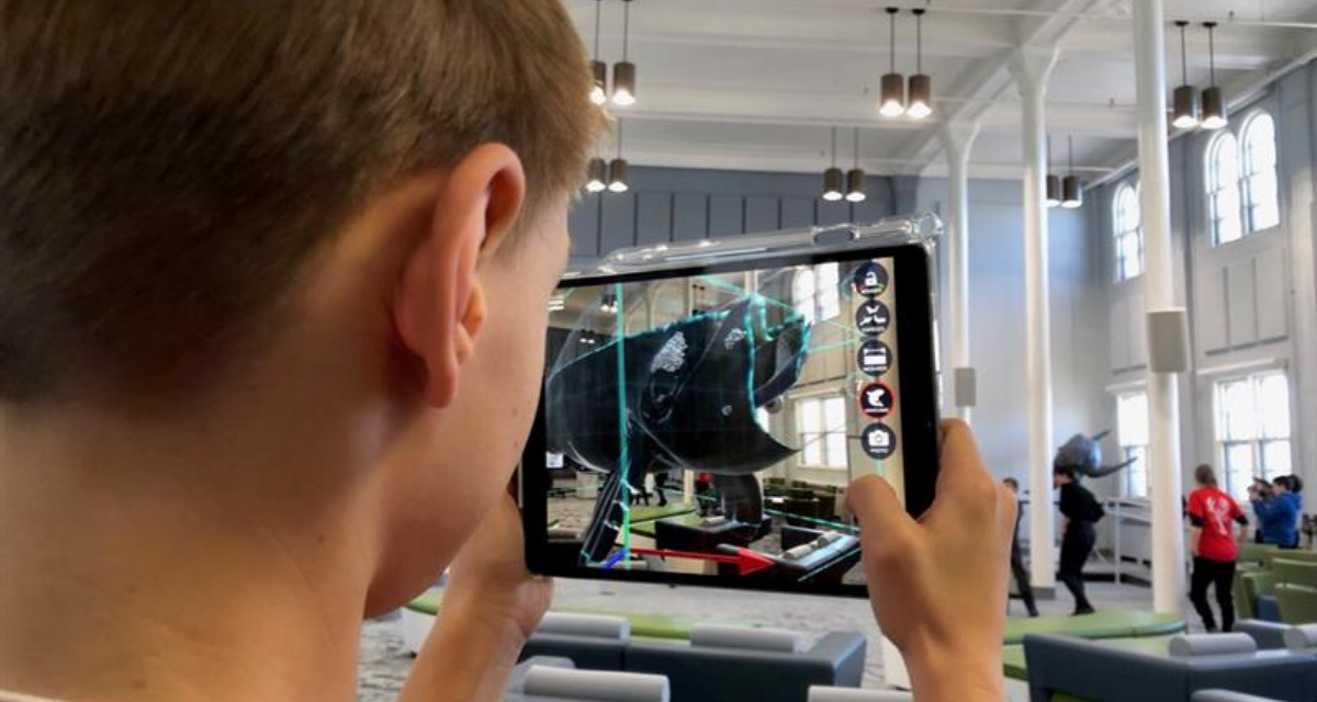 A student looks at the augmented reality right whale from "Where's Whaledo" on a tablet.